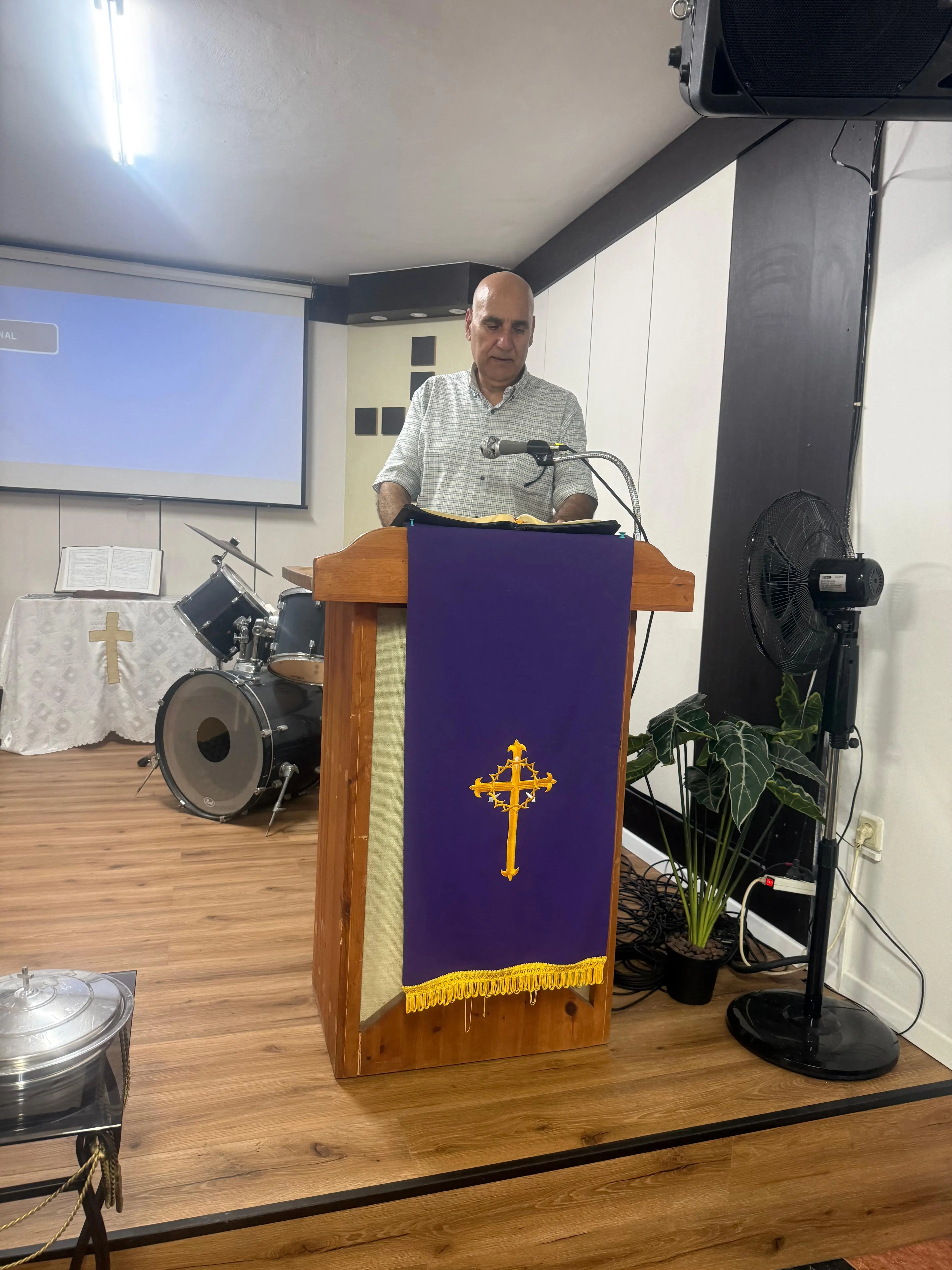 A church member reading from the open Bible during a service at The Greatest Carpenter Church