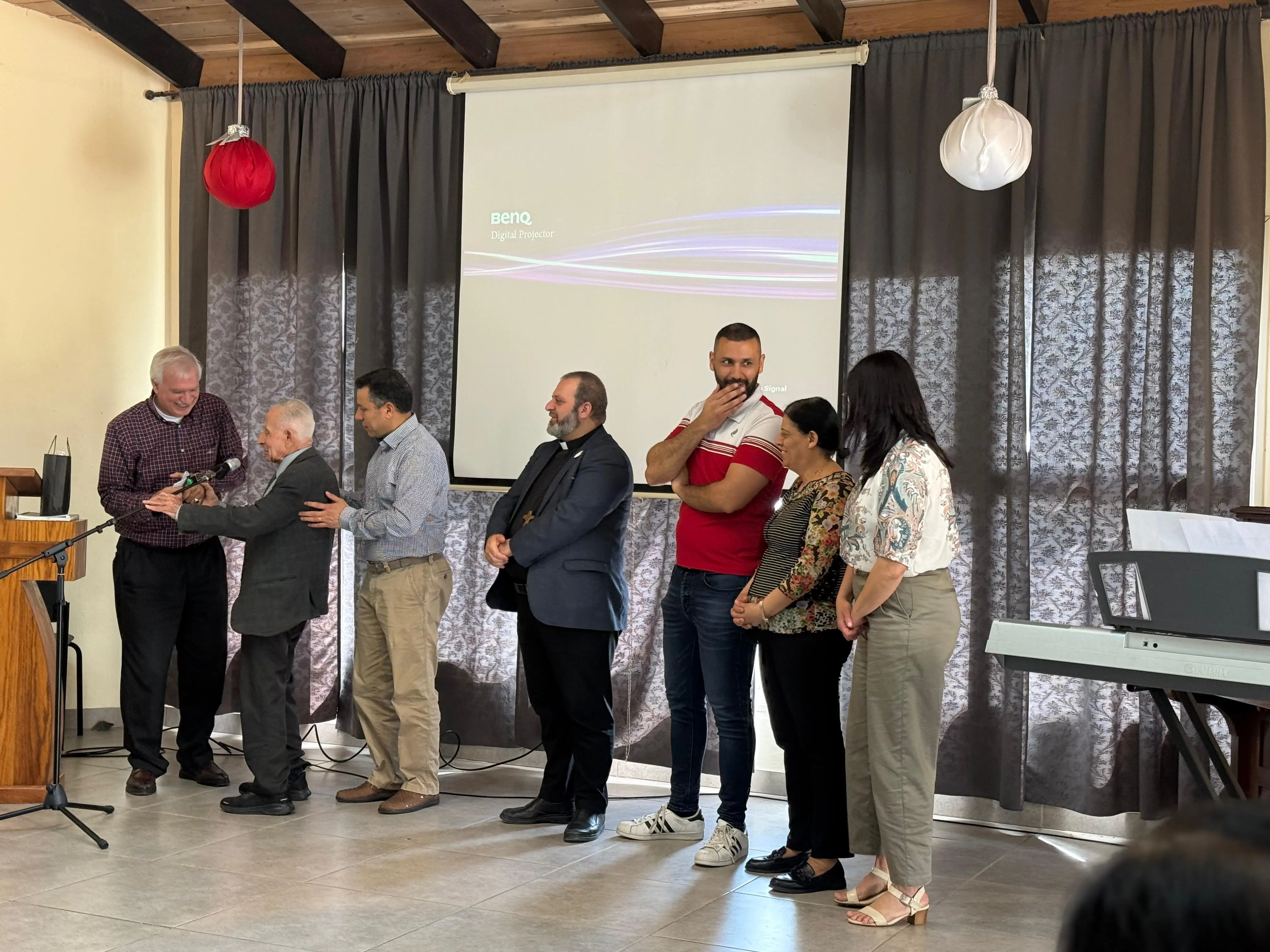 Church leaders and volunteers standing together at the front of the room after a service
